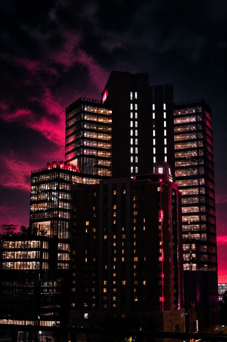 Office towers lit against a deep red night sky